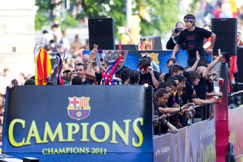 A bus carries Barcelona's players through the streets of Barcelona on May 29, 2011 during a celebratory parade a day after the team won the UEFA Champions League final football match against Manchester United. Tens of thousands of fans burst into the steets of Barcelona on May 28 chanting "Champions! Champions!" as Barca beat Manchester United 3-1 to grab the Champions League crown.  AFP PHOTO/ JAIME REINA (Photo credit should read JAIME REINA/AFP/Getty Images)