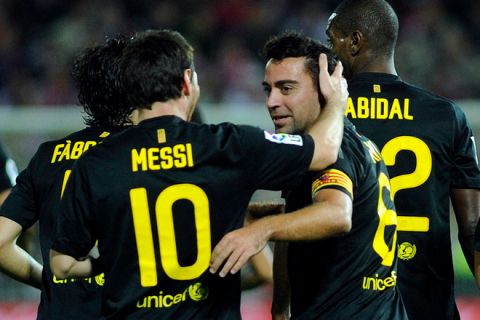 Barcelona's midfielder Xavi Hernandez (R) is congratulated by teammate Barcelona's Argentinian forward Lionel Messi (L) after scoring a goal during the Spanish League football match against Granada, on October 25, 2011 at Los Carmenes stadium in Granada.AFP PHOTO / CRISTINA QUICLER (Photo credit should read CRISTINA QUICLER/AFP/Getty Images)