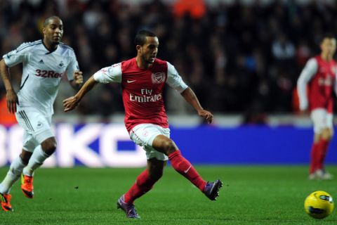 Arsenal's Theo Walcott (C) makess a pass against Swansea City during their English Premiership football match at the Liberty Stadium in Swansea on January 15, 2012.  AFP PHOTO / ADRIAN DENNIS

RESTRICTED TO EDITORIAL USE. No use with unauthorized audio, video, data, fixture lists, club/league logos or live services. Online in-match use limited to 45 images, no video emulation. No use in betting, games or single club/league/player publications. (Photo credit should read ADRIAN DENNIS/AFP/Getty Images)