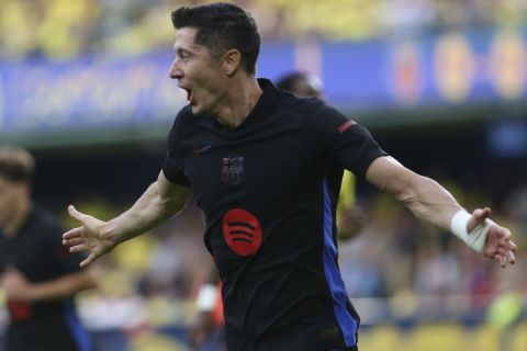 Barcelona's Robert Lewandowski celebrates after scoring the opening goal against Villarreal during a Spanish La Liga soccer match at the La Cerámica stadium in Villarreal, Spain, Sunday, Sept. 22, 2024. (AP Photo/Alberto Saiz)