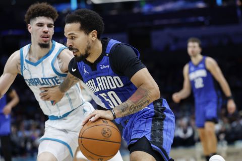 Orlando Magic guard Cole Anthony (50) drives against Charlotte Hornets guard LaMelo Ball, left, during the second half of an NBA basketball game in Charlotte, N.C., Monday, Nov. 25, 2024. (AP Photo/Nell Redmond)