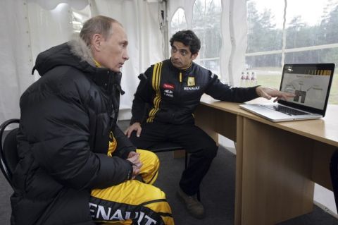 Russia's Prime Minister Vladimir Putin (L) listens to a Renault Formula One team member, who gives instructional advice, before test driving the car at a racing track in Leningrad Region, November 7, 2010.  REUTERS/Ria Novosti/Pool/Alexei Nikolsky  (RUSSIA - Tags: SPORT MOTOR RACING POLITICS) THIS IMAGE HAS BEEN SUPPLIED BY A THIRD PARTY. IT IS DISTRIBUTED, EXACTLY AS RECEIVED BY REUTERS, AS A SERVICE TO CLIENTS