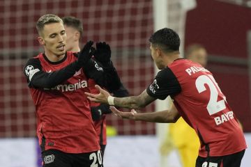 Leverkusen's Alex Grimaldo, left, celebrates with Leverkusen's Exequiel Palacios after scoring during the Champions League opening phase soccer match between Bayer Leverkusen and RB Salzburg at the BayArena in Leverkusen, Germany, Tuesday Nov. 26, 2024. (AP Photo/Martin Meissner)