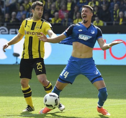 Dortmund's Socratis holds the shirt of Hoffenheim's Sandro Wagner during the German Bundesliga soccer match between Borussia Dortmund and TSG Hoffenheim in Dortmund, Germany, Saturday, May 6, 2017. (AP Photo/Martin Meissner)