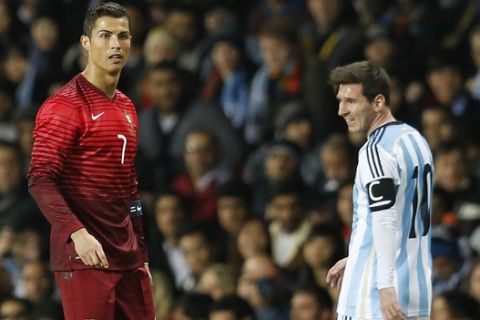 Cristiano Ronaldo of Portugal, left, and Lionel Messi of Argentina stand next to each other during their International Friendly soccer match at Old Trafford Stadium, Manchester, England, Tuesday Nov. 18, 2014. (AP Photo/Jon Super)  