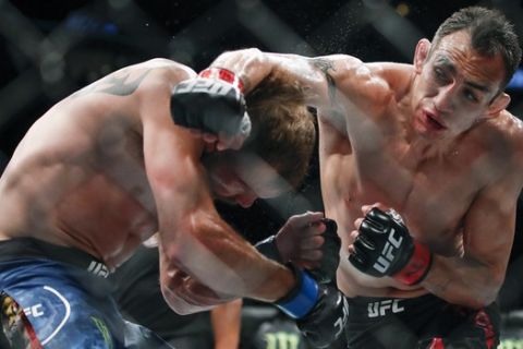 FILE - In this June 8, 2019, file photo, Tony Ferguson, right, punches Donald Cerrone, left, during their lightweight mixed martial arts bout at UFC 238 in Chicago. The UFC says Ferguson will fight Justin Gaethje for the interim lightweight title in the main event of UFC 249 on April 18, 2020. The mixed martial arts promotion announced the matchup Monday, April 6, 2020. Gaethje replaces lightweight champ Khabib Nurmagomedov, who is apparently unable to leave Russia during the coronavirus pandemic. (AP Photo/Kamil Krzaczynski, File)