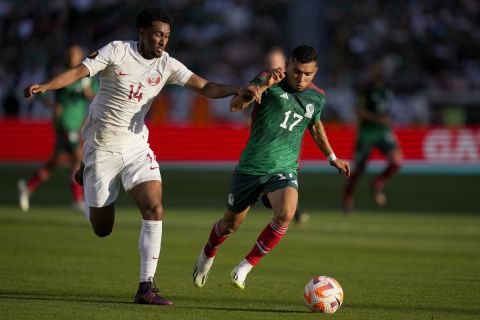 Mexico midfielder Orbelín Pineda, right, moves the ball while defended by Qatar defender Homam Ahmed during the first half of a CONCACAF Gold Cup soccer match Sunday, July 2, 2023, in Santa Clara, Calif. (AP Photo/Godofredo A. Vásquez)