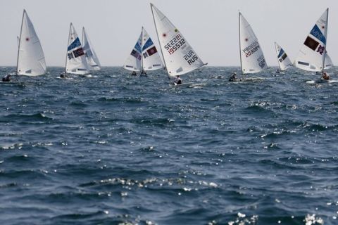 A fleet of Laser class dinghies sail during a practice session ahead of the start of the London 2012 Olympic Games in Weymouth and Portland, southern England, July 21, 2012. REUTERS/Pascal Lauener (BRITAIN - Tags: SPORT YACHTING OLYMPICS)