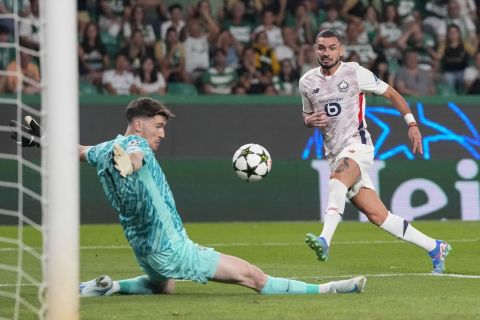 Sporting's goalkeeper Franco Israel, left, makes a save in front of Lille's Remy Cabella during the Champions League opening phase soccer match between Sporting CP and Lille at the Alvalade stadium in Lisbon, Tuesday, Sept. 17, 2024. (AP Photo/Armando Franca)