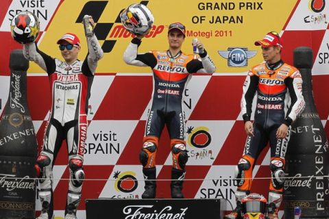 First-placed Honda MotoGP rider Dani Pedrosa of Spain (C) and second-placed Yamaha MotoGP rider Jorge Lorenzo of Spain (L) raise their hands as third-placed Honda MotoGP rider Casey Stoner of Australia looks on, at the podium after the Japanese Grand Prix in Motegi, north of Tokyo October 2, 2011. REUTERS/Yuriko Nakao (JAPAN - Tags: SPORT MOTORSPORT)