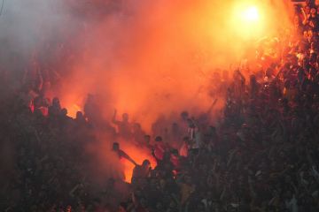 Galatasaray's supporters celebrate the opening goal during the Turkish Super Lig soccer match between Fenerbahce and Galatasaray at the Sukru Saracoglu in Istanbul, Turkey, Saturday, Sept. 21, 2024. (AP Photo/Francisco Seco)