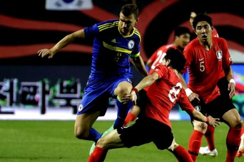 Bosnia and Herzegovina's Edin Dzeko, left, fights for the ball against South Korea's Lee Jae-sung during a friendly soccer match at Jeonju World Cup Stadium in Jeonju, South Korea, Friday, June 1, 2018. (AP Photo/Lee Jin-man)