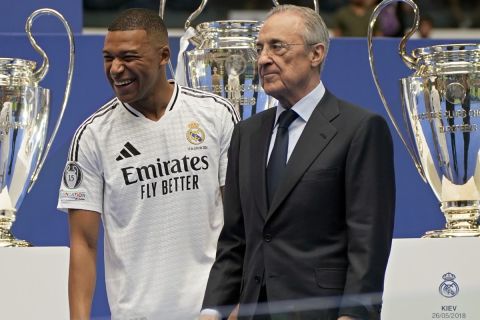 Kylian Mbappe, of France, smiles next to Real Madrid President Florentino Perez while being presented to fans as a new Real Madrid player at the Santiago Bernabeu stadium in Madrid, Tuesday, July 16, 2024. (AP Photo/Andrea Comas)