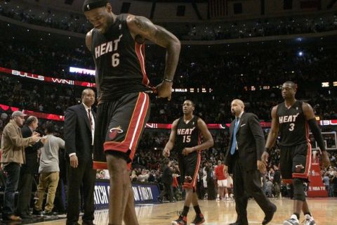 Miami Heat forward LeBron James (L), guard Mario Chalmers (C) and guard Dwayne Wade walk off the floor after losing 93-89 to the Chicago Bulls in their NBA basketball game in Chicago, Illinois February 24, 2011. REUTERS/Frank Polich (UNITED STATES - Tags: SPORT BASKETBALL)