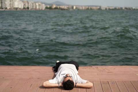 Ο Γιάννης Μιχαηλίδης ξαπλωμένος στην παραλία της Θεσσαλονίκης