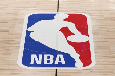 FILE - The NBA logo in shown on a basketball court in Lake Buena Vista, Fla., in this Friday, Aug. 28, 2020, file photo. Pacers coach Rick Carlisle says his new team has a very high vaccination rate but declined to give a specific number because of privacy concerns. He did say Monday during NBA media day that all members of the Indiana coaching staff are fully vaccinated. Carlisle is back in Indiana, where he coached from 2003 through 2007. Training camps open Tuesday and the pandemic will affect a third NBA season and already means some players will be missing on media day.(AP Photo/Ashley Landis, Pool, File)