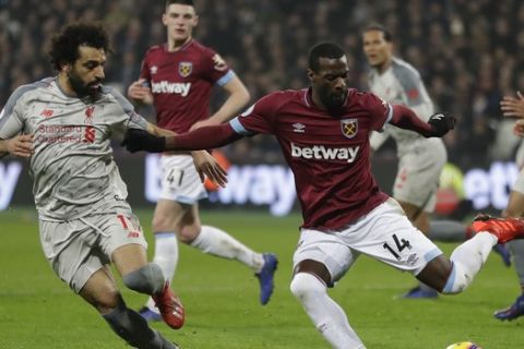 Liverpool's Mohamed Salah, left, and West Ham's Pedro Obiang challenge for the ball during the English Premier League soccer match between West Ham United and Liverpool at the London Stadium in London, Monday, Feb. 4, 2019.(AP Photo/Kirsty Wigglesworth)