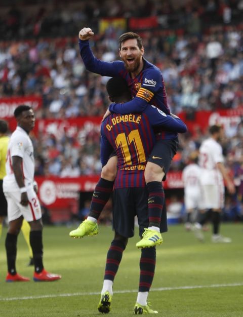 Barcelona forward Lionel Messi with his teammate Ousmane Dembele celebrate after scoring his side's second goal during La Liga soccer match between Sevilla and Barcelona at the Ramon Sanchez Pizjuan stadium in Seville, Spain. Saturday, February 23, 2019. (AP Photo/Miguel Morenatti)