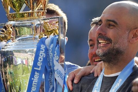 Manchester City coach Pep Guardiola lifts the English Premier League trophy after the English Premier League soccer match between Brighton and Manchester City at the AMEX Stadium in Brighton, England, Sunday, May 12, 2019. Manchester City defeated Brighton 4-1 to win the championship. (AP Photo/Frank Augstein)