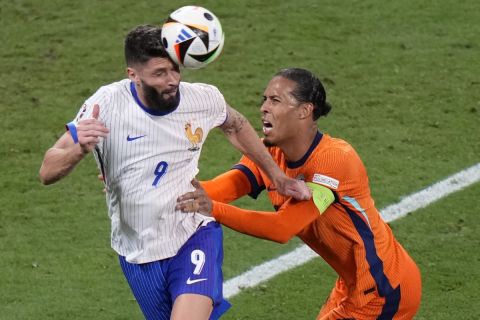 Virgil van Dijk of the Netherlands, right, holds Olivier Giroud of France during a Group D match between the Netherlands and France at the Euro 2024 soccer tournament in Leipzig, Germany, Friday, June 21, 2024. (AP Photo/Sergei Grits)