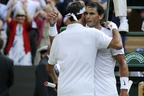 Switzerland's Roger Federer hugs Spain's Rafael Nadal after defeating him in a men's singles semifinal match on day eleven of the Wimbledon Tennis Championships in London, Friday, July 12, 2019. (AP Photo/Ben Curtis)