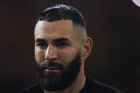 Al Ittihad's Karim Benzema stands at the pitch under the rain prior the Soccer Club World Cup first round soccer match between Al Ittihad and Auckland City FC at King Abdullah Sports City stadium in Jeddah, Saudi Arabia, Tuesday, Dec. 12, 2023. (AP Photo/Manu Fernandez)