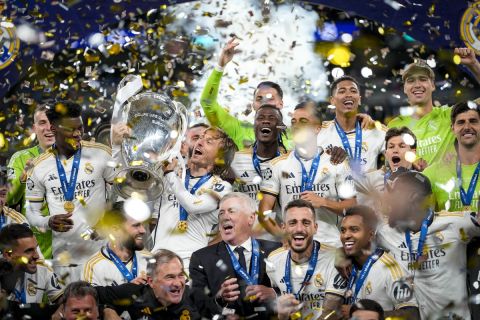 Real Madrid's players celebrate with the trophy after winning the Champions League final soccer match between Borussia Dortmund and Real Madrid at Wembley stadium in London, Saturday, June 1, 2024. (AP Photo/Kirsty Wigglesworth)