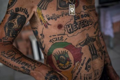 TO GO WITH AFP STORY by Javier Tovar
Brazilian football club Botafogo fan Delneri Martins Viana, a 69-year-old retired soldier, shows his tattoos at his home in Rio de Janeiro, Brazil, on January 18, 2014. Delneri has 83 tattoos on his body dedicated to Botafogo and describes himself as the club's biggest fan.   AFP PHOTO / YASUYOSHI CHIBA