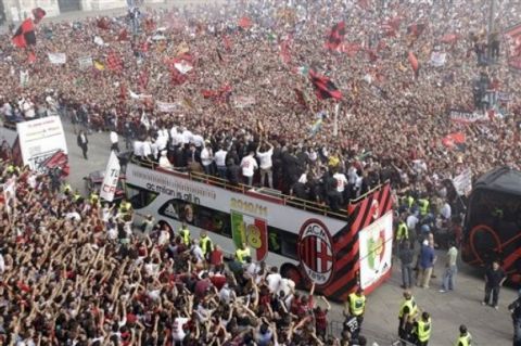 Thousands of fans cheer as a bus carries the triumphant AC Milan soccer team players celebrating their 18th Italian Serie A top league title, in front of the Milan gothic cathedral, Italy, Saturday, May 14, 2011. AC Milan ended five years of dominance by city rival Inter Milan last Saturday, clinching its first Serie A title since 2004. (AP Photo/Luca Bruno)