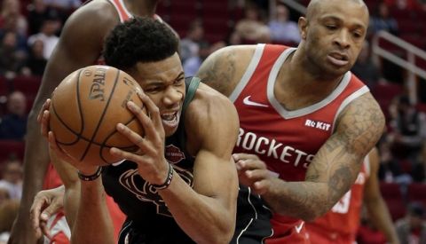 Milwaukee Bucks forward Giannis Antetokounmpo, left, protects his rebound from Houston Rockets forward PJ Tucker, right, during the first half of an NBA basketball game Wednesday, Jan. 9, 2019, in Houston. (AP Photo/Michael Wyke)