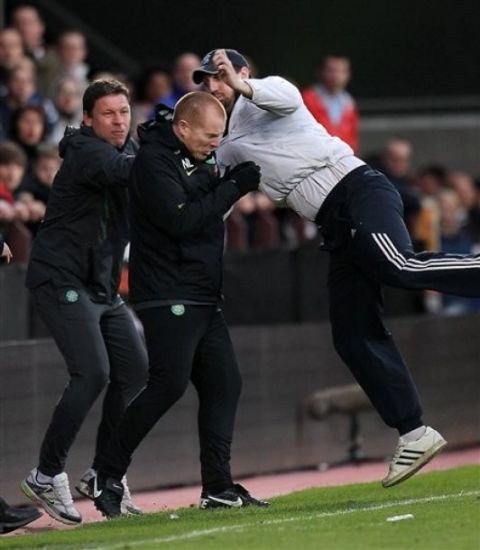 Celtic's manager Neil Lennon is attacked by a fan during the Scottish Premier League soccer match at Tynecastle Stadium, Edinburgh Wednesday May 11, 2011, after Gary Hooper had put the visitors two goals ahead. Before the game could restart a fan clambered from the Hearts section of the main stand and went for the Celtic boss who was on the touchline, leading to an intervention by police and stewards.  Lennon has been under 24-hour security surveillance after letter bombs were intercepted addressed to him. (AP Photo/ Lynne Cameron/PA)  UNITED KINGDOM OUT  NO SALES  NO ARCHIVE