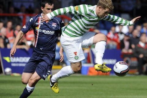 Celtic's Kris Commons is challenged by Ross County's Marc Fitzpatrick (L) during their Scottish Premier League soccer match at Victoria Park in Dingwall, Scotland August 18, 2012. REUTERS/Russell Cheyne (BRITAIN - Tags: SPORT SOCCER)