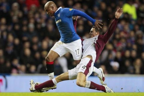 Rangers' El Hadji Diouf (L) is tackled by Hearts' Eggert Jonsson during their Scottish Premier League soccer match at Ibrox stadium in Glasgow, Scotland February 2, 2011. REUTERS/David Moir (BRITAIN - Tags: SPORT SOCCER)