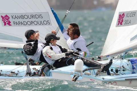 Greece's Efstathios Papadopoulos and Panagiotis Kampouridis (R) pass Israel's Eran Sela and Gideon Kliger (L) in the 470 sailing class at the London 2012 Olympic Games, in Weymouth on August 2, 2012.  AFP PHOTO/William WEST        (Photo credit should read WILLIAM WEST/AFP/GettyImages)