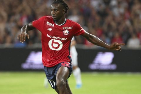 Lille's Ngal'ayel Mukau runs with the ball watched by PSG's Warren Zaire-Emery, left, during the French League 1 soccer match between Lille and Paris Saint-Germain, in Villeneuve-d'Ascq, France, Sunday, Sept. 1, 2024. (AP Photo/Matthieu Mirville)