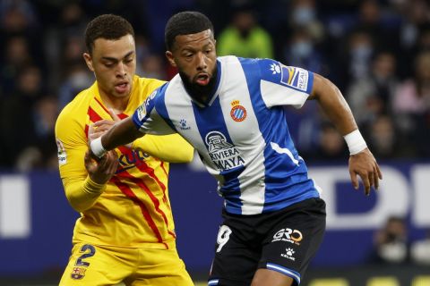 Barcelona's Sergino Dest fights for the ball with Espanyol's Tonny Vilhena, right, during a Spanish La Liga soccer match between RCD Espanyol and Barcelona at the Cornella-El Prat stadium in Barcelona, Spain, Sunday, Feb. 13, 2022. (AP Photo/Joan Monfort)