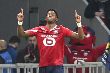 Lille's Jonathan David celebrates after scoring his side's opening goal during the French League One soccer match between Lille and Marseille at the Pierre Mauroy stadium in Villeneuve d'Ascq, northern France, Friday, April 5, 2024. (AP Photo/Matthieu Mirville)