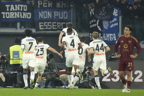 Atalanta players celebrate a goal from they teammate Marten de Roon during the Italian Series A soccer match between Roma and Atalanta, at Rome's Olympic Stadium, Monday, Dec. 2, 2024. (AP Photo/Gregorio Borgia)