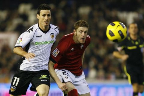 Osasuna's Sergio Fernandez (R) and Valencia's Aritz Aduriz fight for the ball during their Spanish first division soccer match at the Mestalla Stadium in Valencia December 13, 2010. REUTERS/Heino Kalis (SPAIN - Tags: SPORT SOCCER)