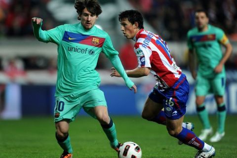 GIJON, SPAIN - FEBRUARY 12:  Lionel Messi (L) of Barcelona duels for the ball with Andre Castro of Sporting Gijon during the la Liga match between Sporting Gijon and Barcelona at El Molinon Stadium on February 12, 2011 in Gijon, Spain.  (Photo by Jasper Juinen/Getty Images)