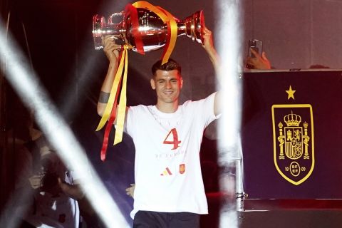 Spain's team captain Alvaro Morata arrives on stage carrying the trophy during celebrations of the Spanish team's European soccer championship title on a stage at Cibeles square in Madrid, Monday, July 15, 2024. Spain defeated England in the final of the Euro 2024 soccer tournament in Berlin on Sunday evening. (AP Photo/Andrea Comas)