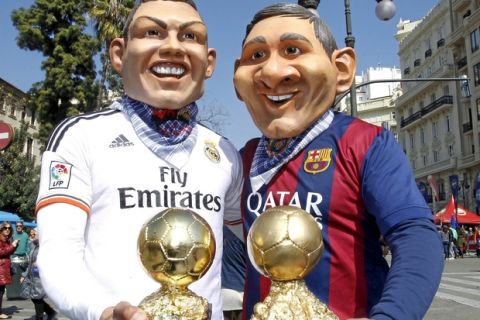 Personas con cabezas de Cristiano Ronaldo y Messi en las Fallas de Valencia.

Men dressed up as Cristiano Ronald and Messi during Las Fallas in Valencia.