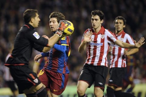 Athletic Bilbao's goalkeeper Gorka Iraizoz (L) catches the ball next to Barcelona's Leo Messi and Athletic's Andoni Iraola during their Spanish King's Cup soccer match at San Mames stadium in Bilbao January 5, 2011. REUTERS/Vincent West (SPAIN - Tags: SPORT SOCCER)