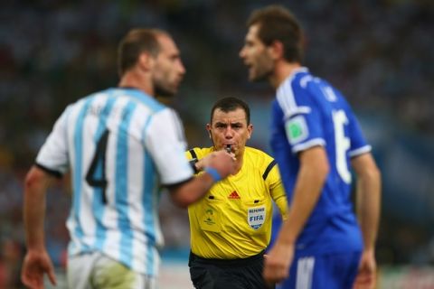 RIO DE JANEIRO, BRAZIL - JUNE 15: Referee Joel Aguilar reacts as Pablo Zabaleta of Argentina (L) and Senad Lulic of Bosnia and Herzegovina clash during the 2014 FIFA World Cup Brazil Group F match between Argentina and Bosnia-Herzegovina at Maracana on June 15, 2014 in Rio de Janeiro, Brazil.  (Photo by Julian Finney/Getty Images)