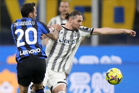 Inter Milan's Hakan Calhanoglu, left, and Juventus' Adrien Rabiot challenge for the ball during a Italian cup semi final second leg soccer match between Inter Milan and Juventus at the San Siro stadium in Milan, Italy, Wednesday, April 26, 2023. (AP Photo/Luca Bruno)