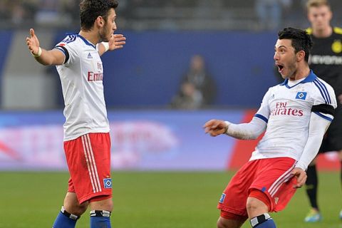 Hamburg's Turkish midfielder Hakan Calhanoglu (L) celebrates with Hamburg's Turkish midfielder Tolgay Arslan after the German first division Bundesliga football match Hamburger SV vs Borussia Dortmund on February 22, 2014 in Hamburg, northern Germany. Hamburg won 3-0. AFP PHOTO / CARMEN JASPERSEN

DFL RULES TO LIMIT THE ONLINE USAGE DURING MATCH TIME TO 15 PICTURES PER MATCH. FOR FURTHER QUERIES PLEASE CONTACT DFL DIRECTLY AT + 49 69 650050.        (Photo credit should read CARMEN JASPERSEN/AFP/Getty Images)