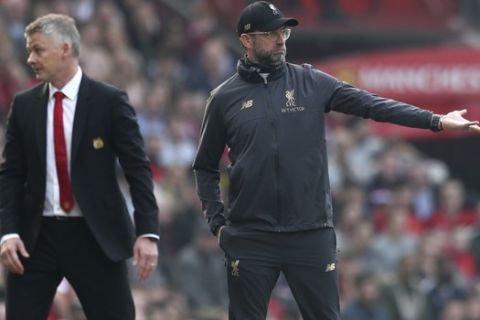 Manchester United manager Ole Gunnar Solskjaer, left, and Liverpool manager Juergen Klopp during the English Premier League soccer match between Manchester United and Liverpool at Old Trafford stadium in Manchester, England, Sunday, Feb. 24, 2019. (AP Photo/Jon Super)