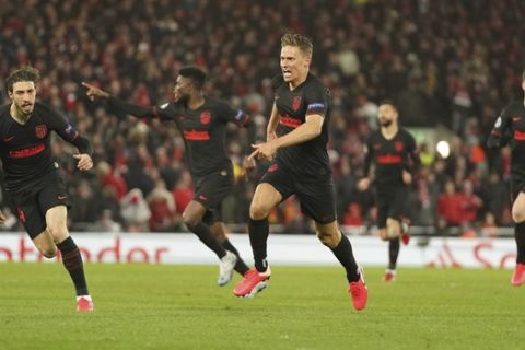 Atletico Madrid's Marcos Llorente, center, celebrates after scoring his side's opening goal during a second leg, round of 16, Champions League soccer match between Liverpool and Atletico Madrid at Anfield stadium in Liverpool, England, Wednesday, March 11, 2020. (AP Photo/Jon Super)