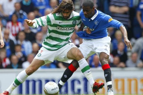 Celtic's Georgios Samaras (L) holds off Rangers' Maurice Edu during their Scottish Premier League 'Old Firm' soccer match at Ibrox Stadium in Glasgow, Scotland April 24, 2011. REUTERS/David Moir (BRITAIN - Tags: SPORT SOCCER)