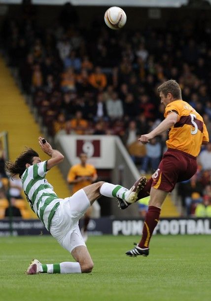 Celtic's Georgios Samaras (L) challenges Motherwell's Stephen Craigan and receives a yellow card during their Scottish Premier League soccer match at Fir Park in Motherwell, Scotland, August 29, 2010. REUTERS/Russell Cheyne (BRITAIN - Tags: SPORT SOCCER)